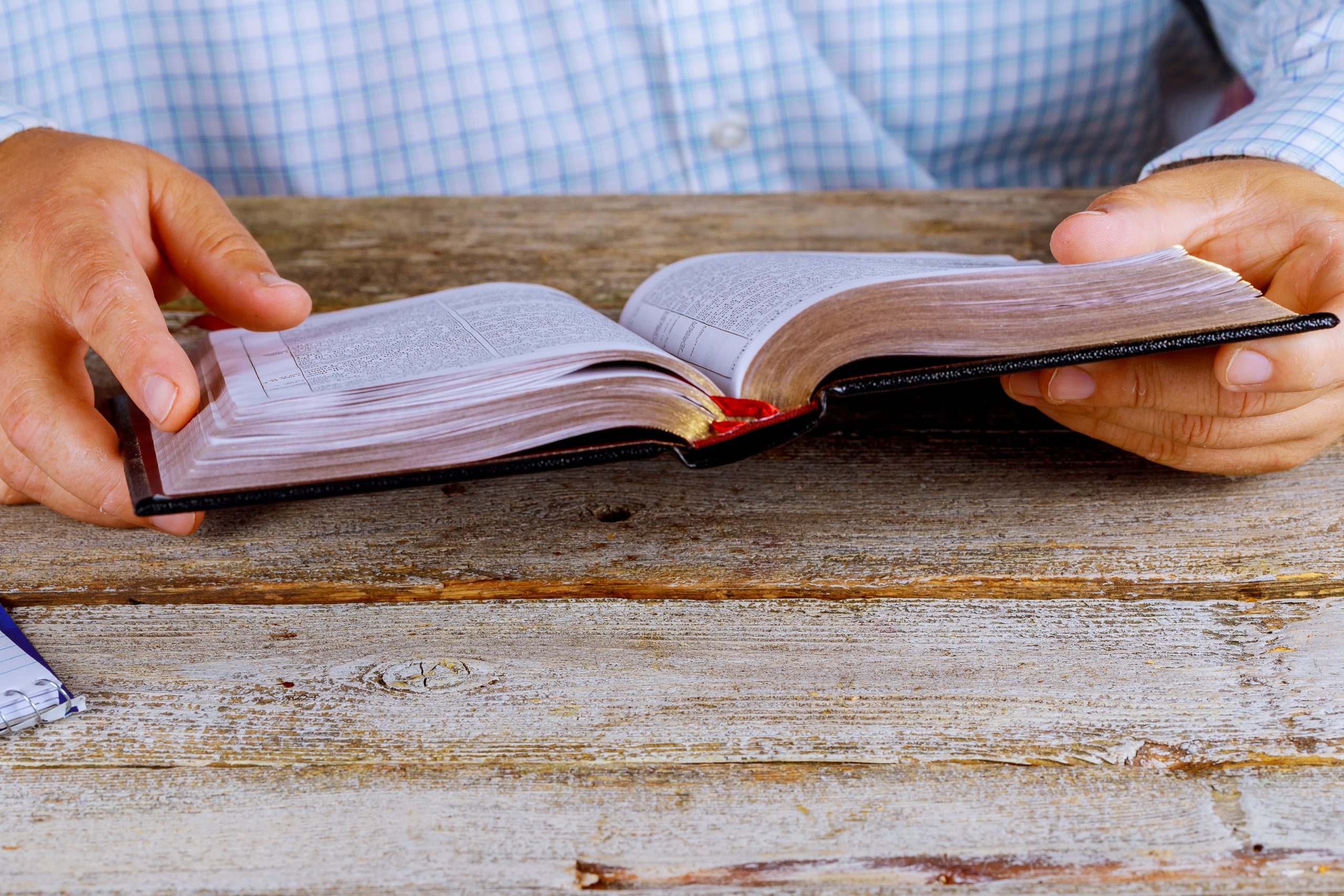 A men sitting reading the Holy Bible close up hands