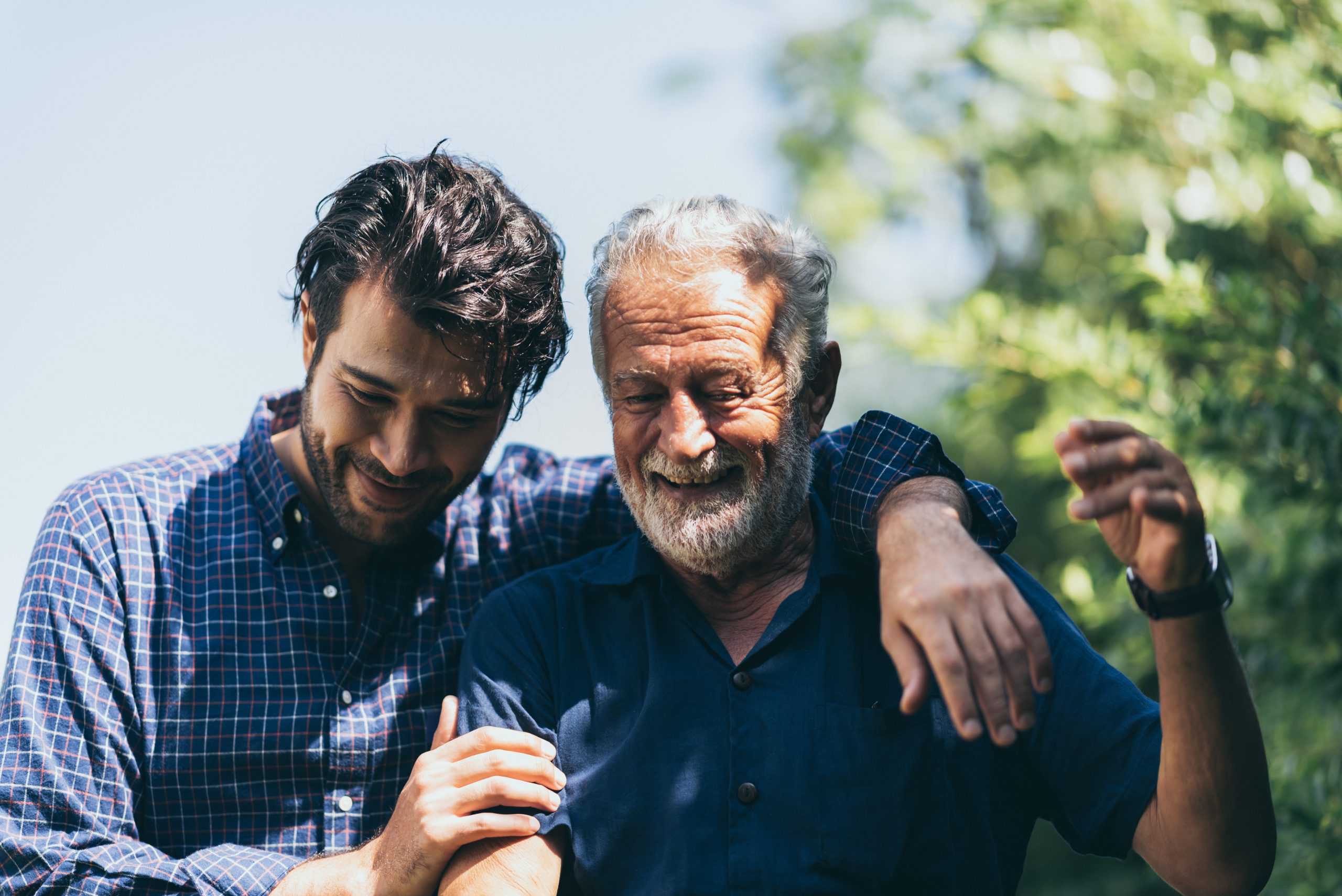 An adult hipster son and senior father at home, talking.