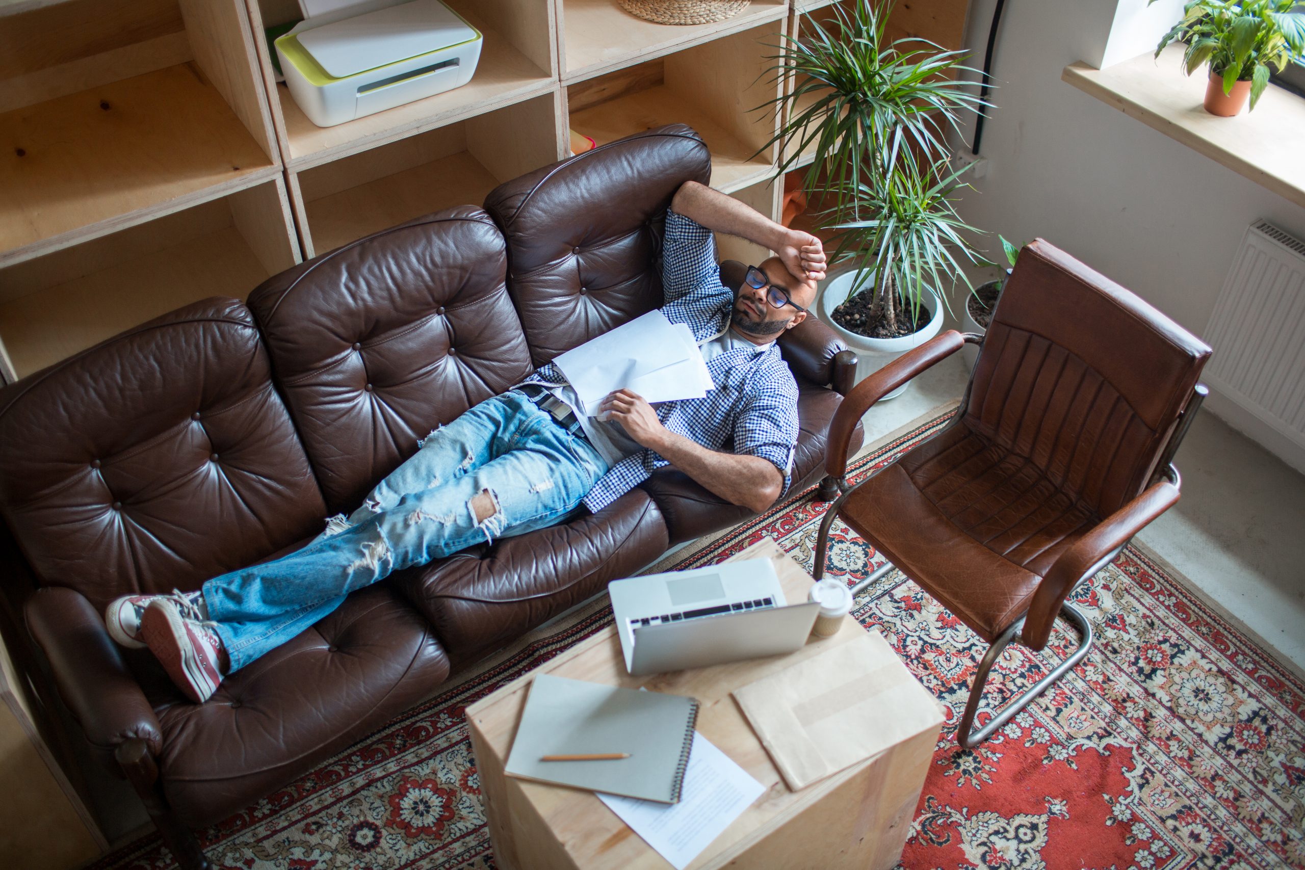 Exhausted man with papers having short break for sleep between work