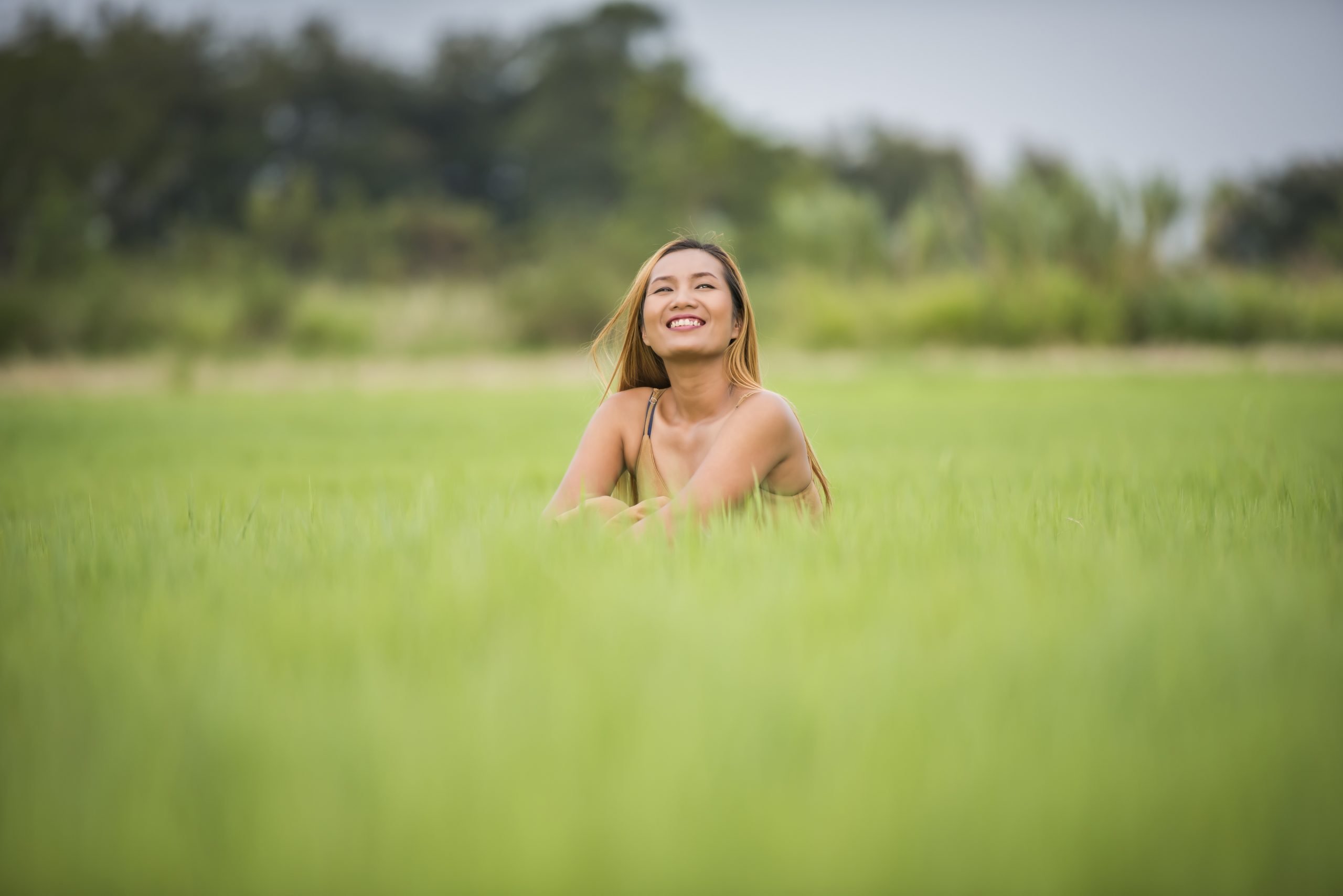 Young woman sitting feel good in grass field.