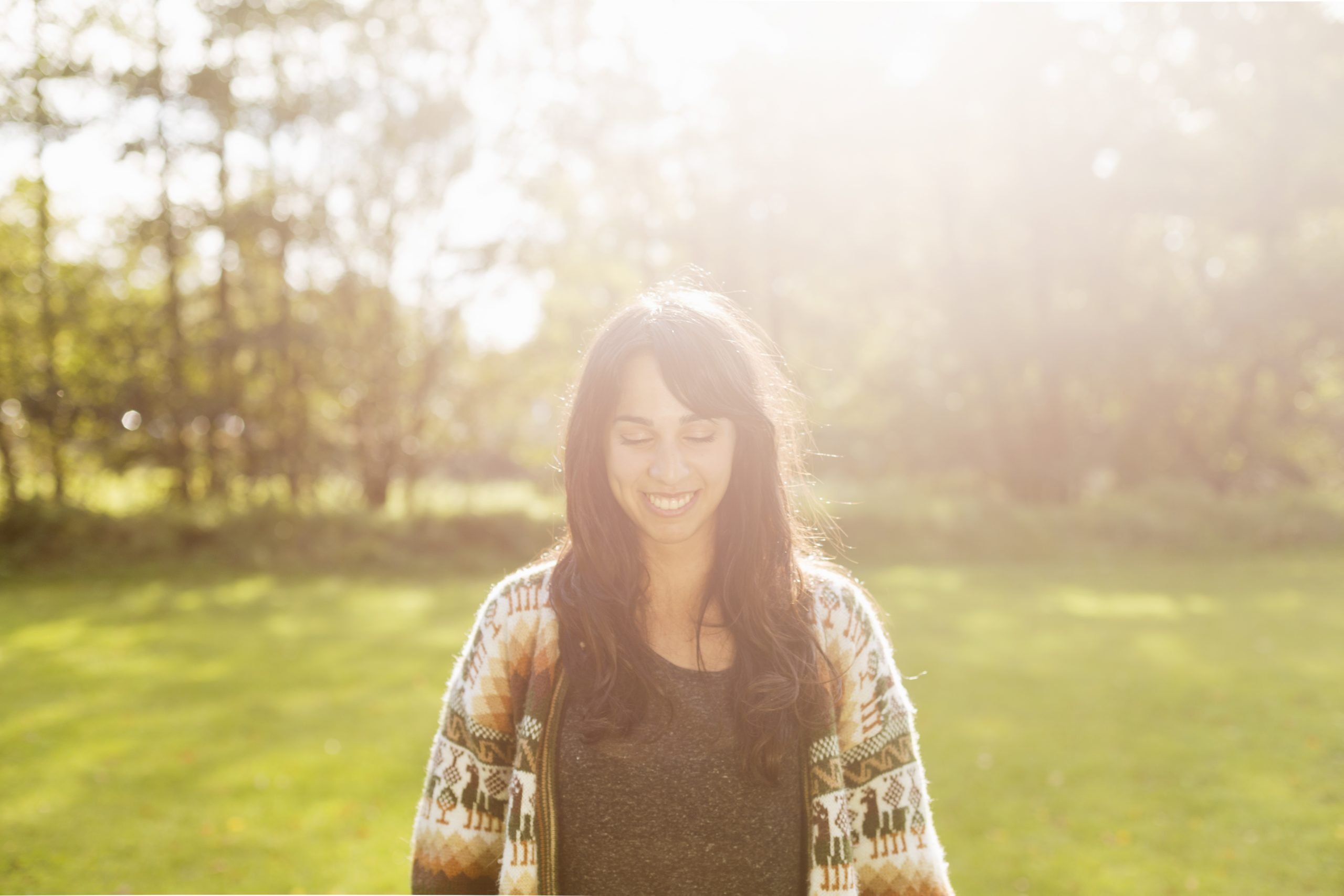 Happy young woman with eyes closed at field