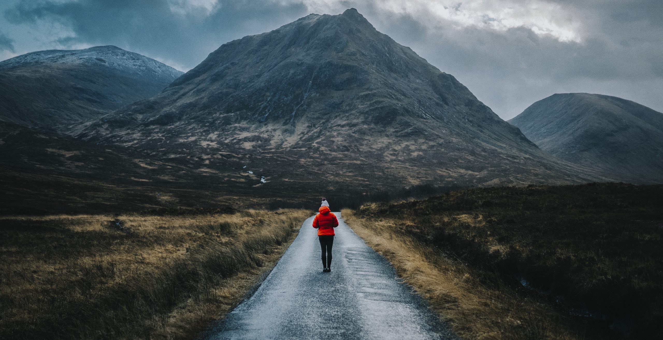 Woman walking on a road in Glen Etive, Scotland