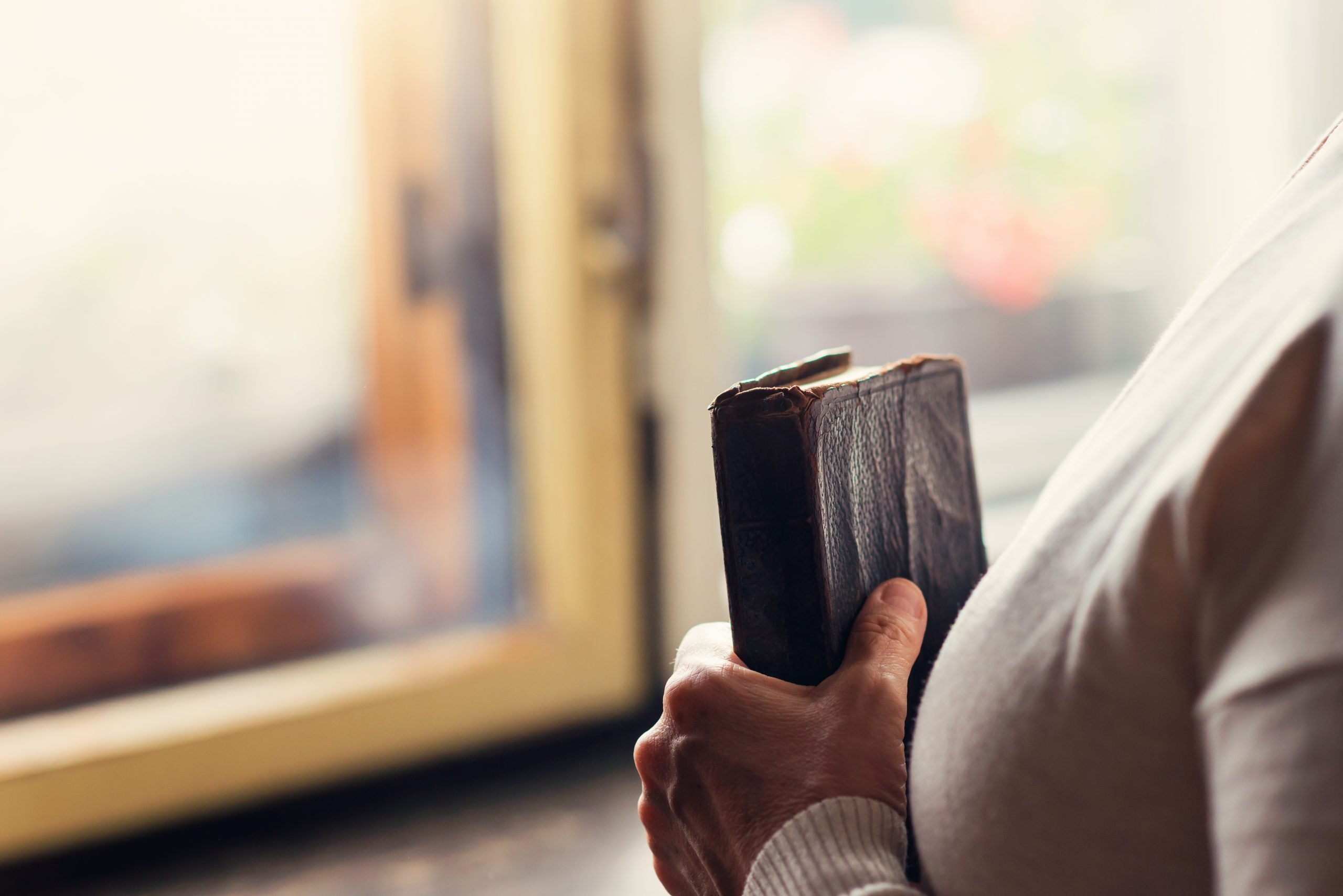 Unrecognizable woman holding a bible in her hands