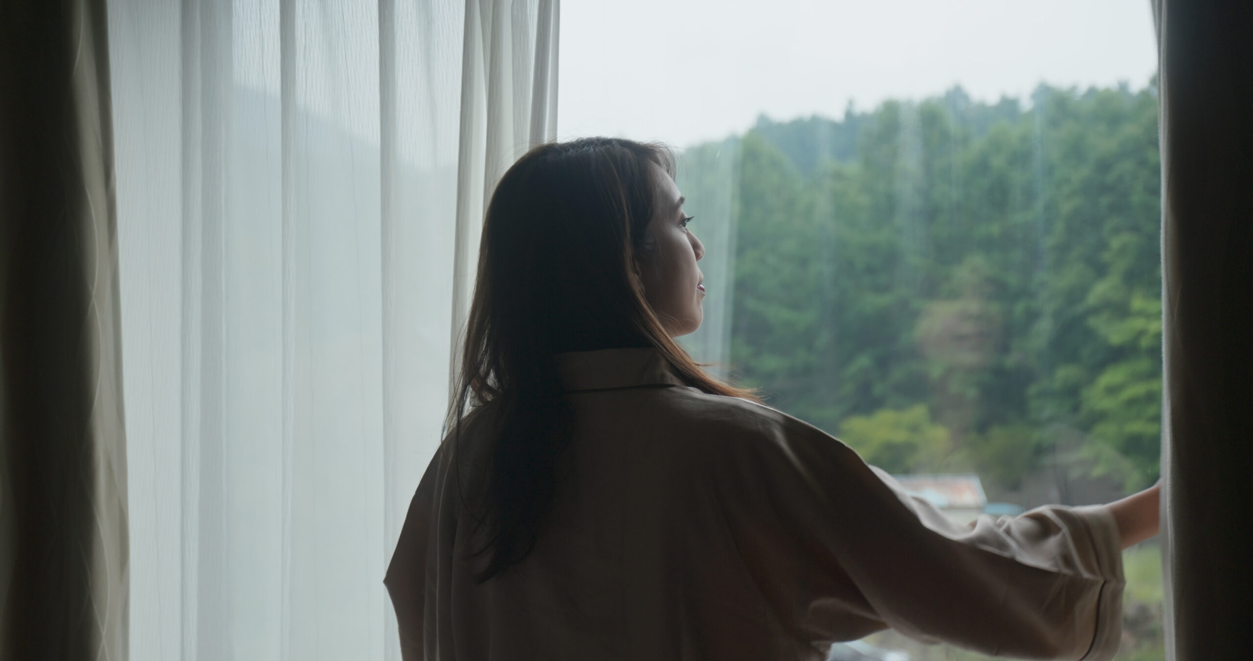 Woman wake up at morning and open the curtain at hotel room