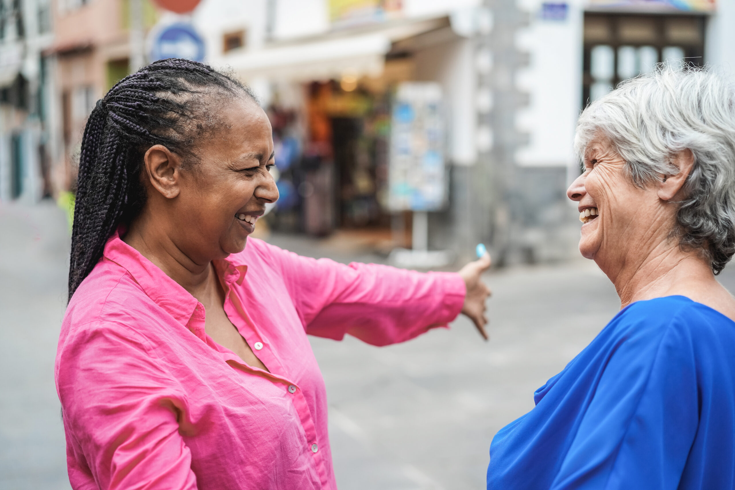 Senior multiracial women meeting and hugging each others outdoor - Focus on african female face