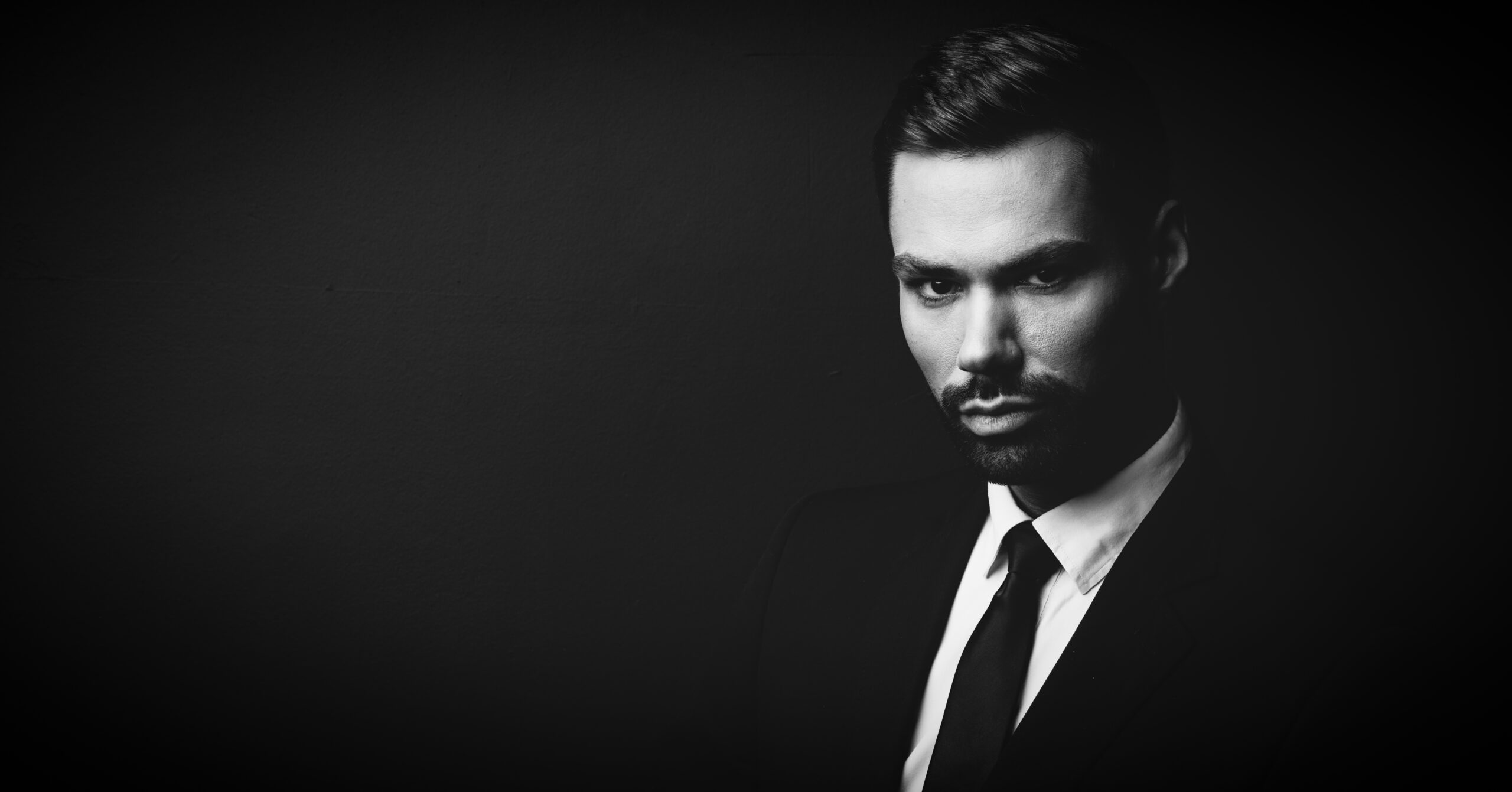 Black and white portrait of young businessman in a suit. Stylish person.