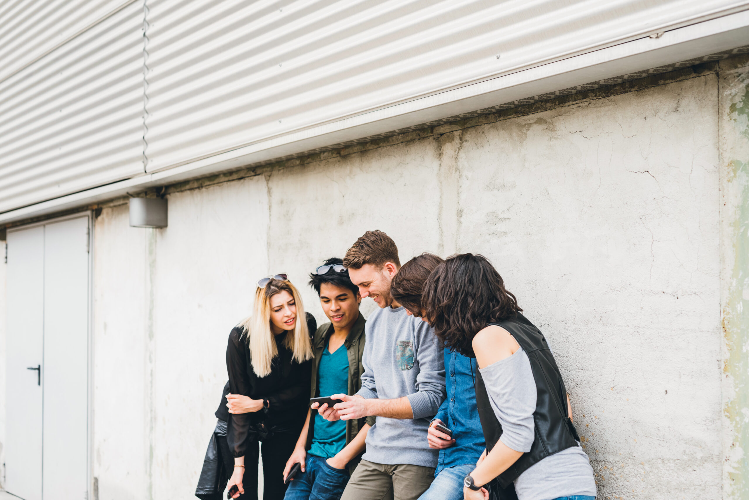 Group of multiethnic friends millennials using smartphone addicted to technology trends following and chatting  and watching videos