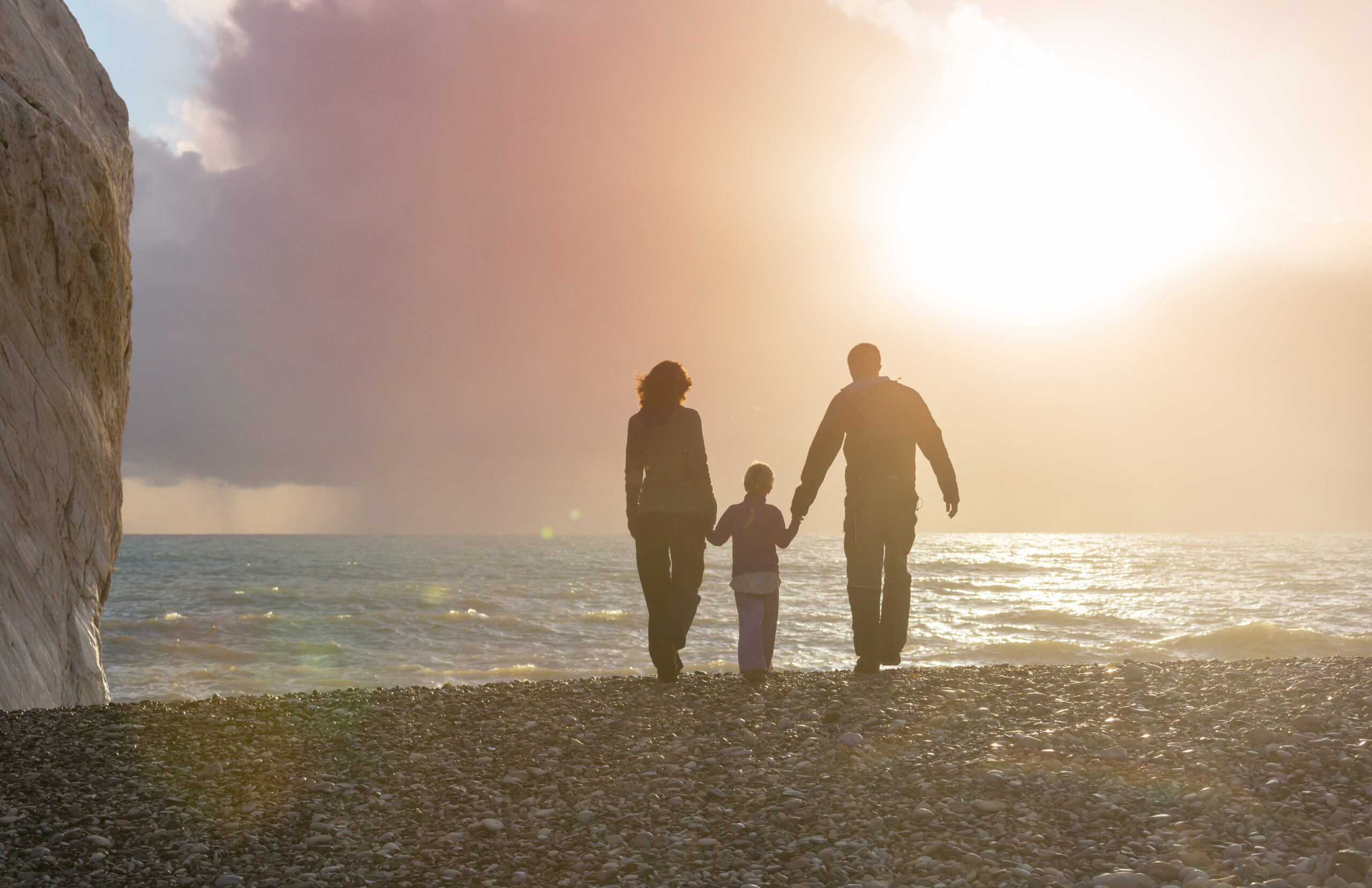 Family on the beach on sunset. Mother and daughter running together.