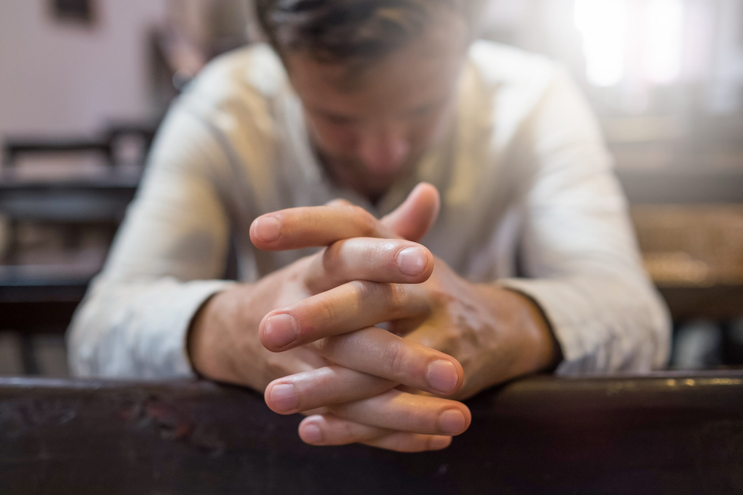 caucasian man praying in church. He has problems and ask God for help. Concept of religion faith