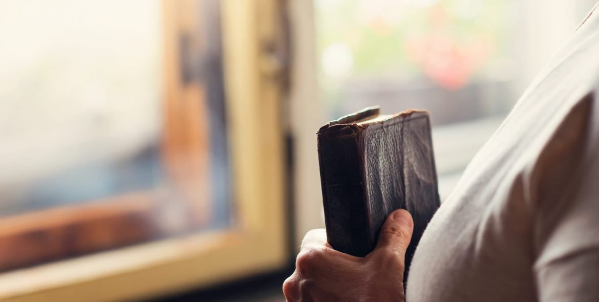 Unrecognizable woman holding a bible in her hands