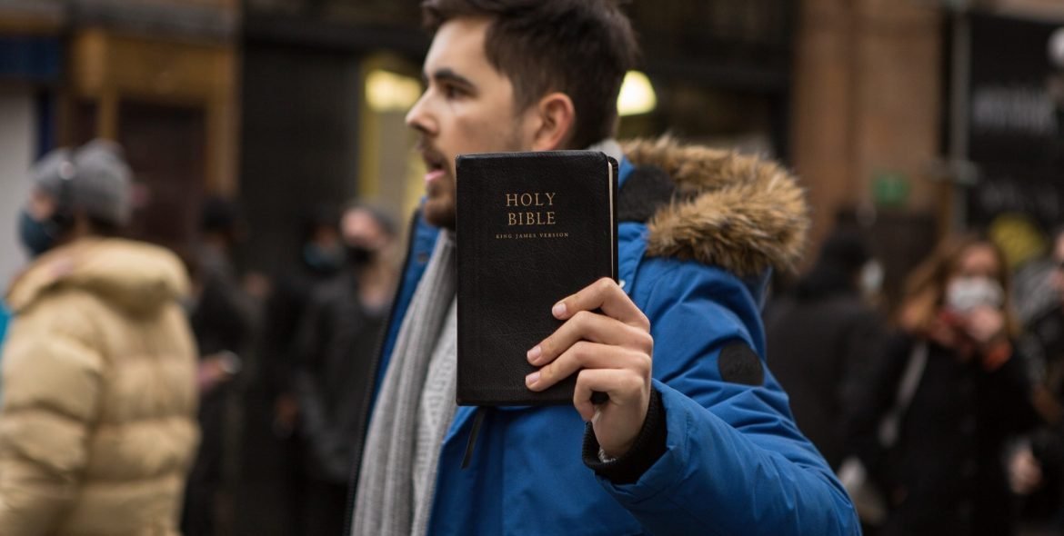 bible-basher-tries-in-an-enthusiastic-way-to-persuade-other-people-to-believe-in-the-bible_t20_dr3zWj