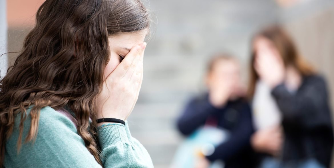 Girl being bullied at the school. Educational school isolation and bullying concept.
