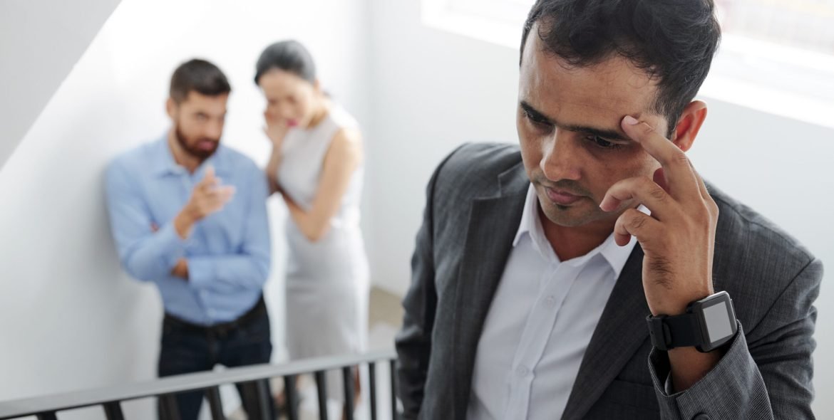 Businessman tired of hearing gossips behind his back, he is walking up the stairs and eavesdropping on conversation of colleagues