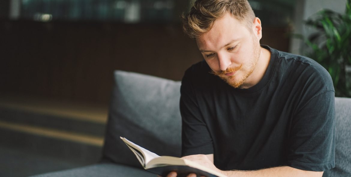 Christian man holds holy bible in hands. Reading the Holy Bible in a home. Concept for faith, spirituality and religion. Peace, hope