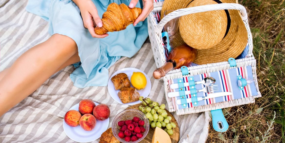 Close up image of elegant woman enjoy her meal with vintage retro picnic basket