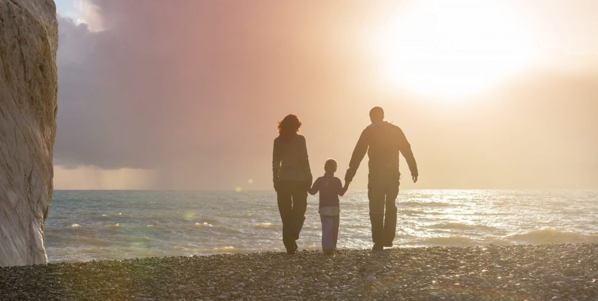 Family on the beach on sunset. Mother and daughter running together.