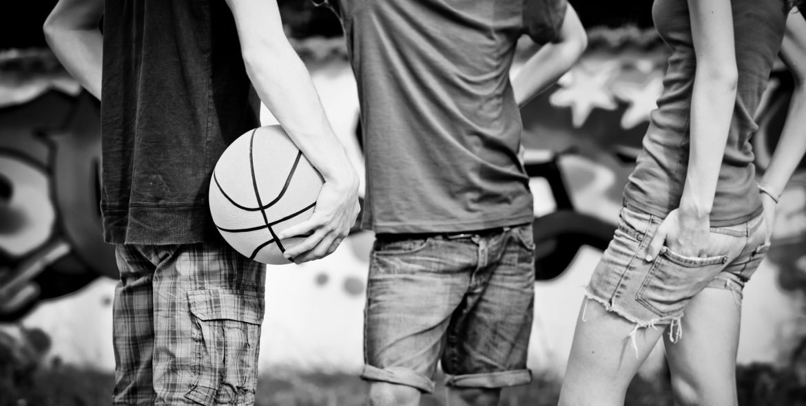 Group of friends talking and taking a break after playing basketball