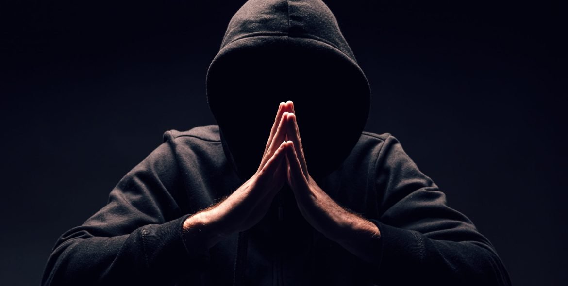 Hooded incognito man. Mysterious man wit hoodie on black background