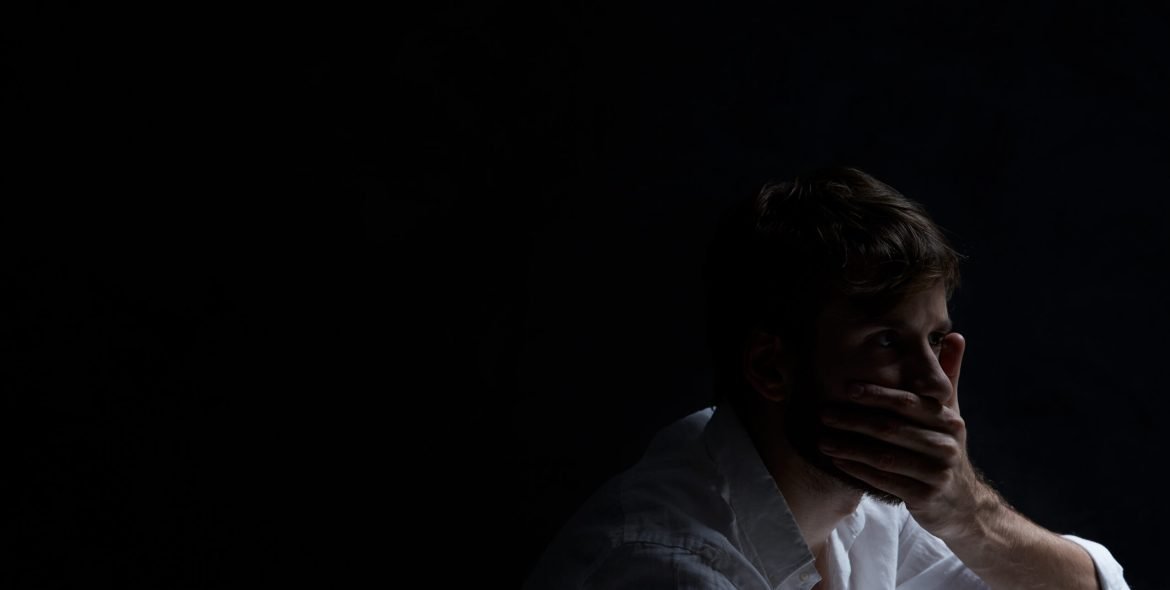 Alone man covering his mouth by his hand