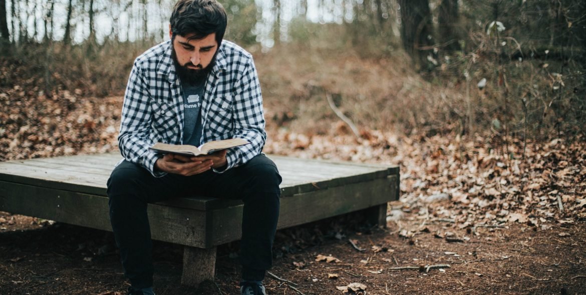 man-reading-his-bible-in-the-woods-2022-03-06-04-19-35-utc
