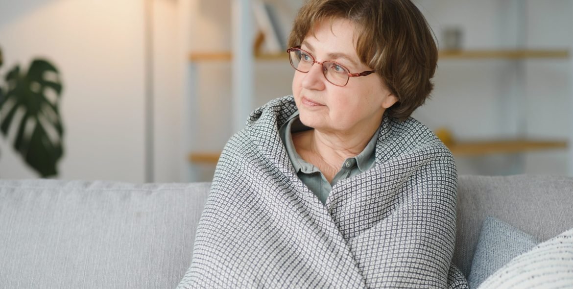 Pensive thoughtful middle aged lady looking away sit alone at home feel anxious lonely, sad depressed melancholic old mature woman suffer from sorrow grief thinking of problem suffer from solitude