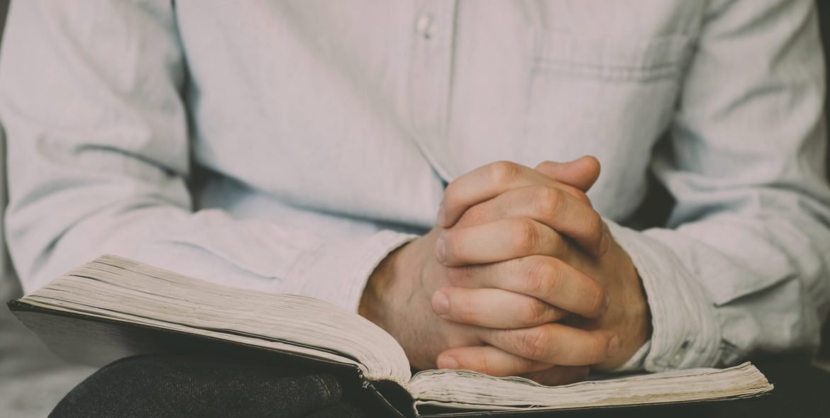 The Christian holds the Bible in his hands. Reading the bible. The concept of faith, spirituality and religion.