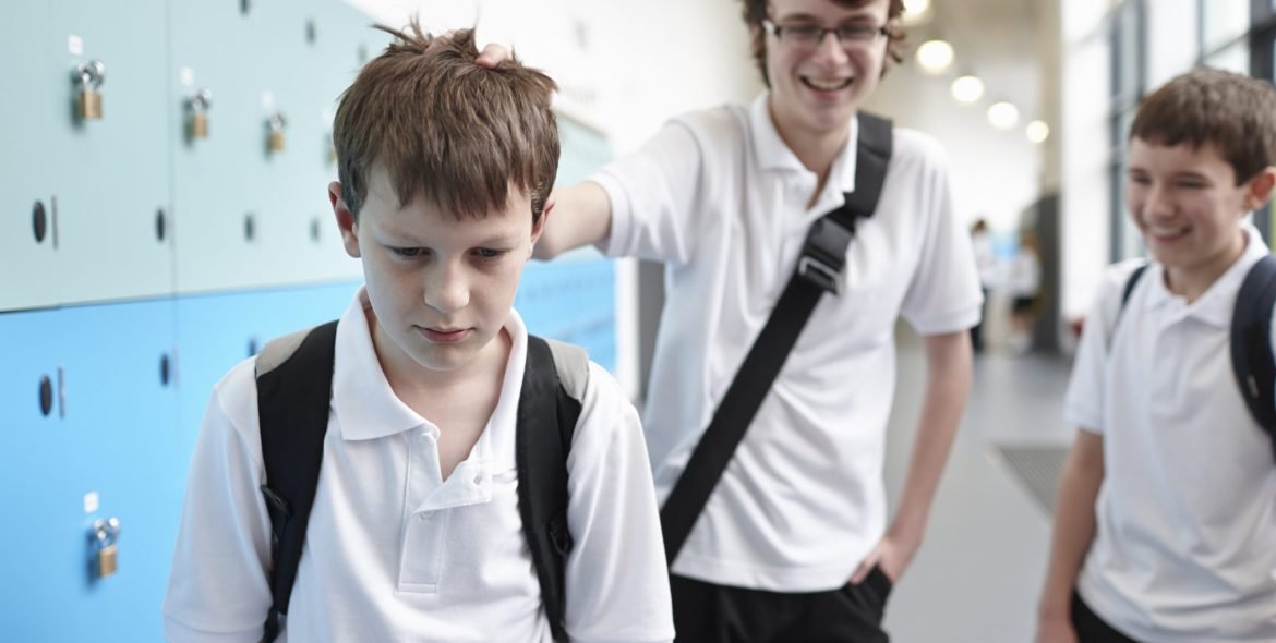Schoolboy being bullied in school corridor