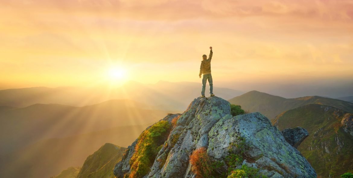 Silhouette of a champion on mountain top. Travel and adventure. Mountain hiking. Mountains during sunrise. Success and goal achievement. People success-image