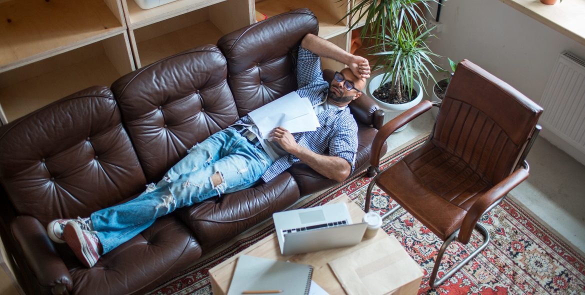 Exhausted man with papers having short break for sleep between work