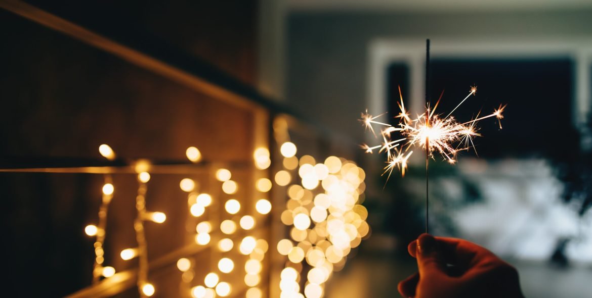Sparklers on blurred christmas lights. Festive mood. High quality photo