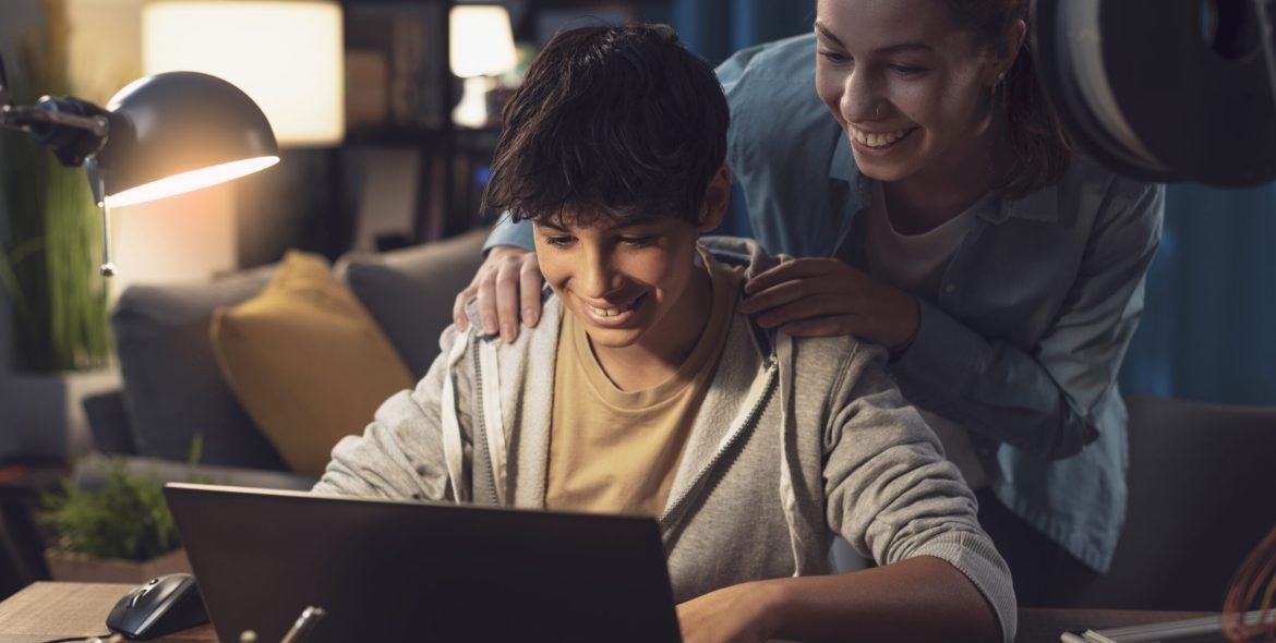 Teenagers learning 3D modeling and using a 3D printer, the boy is using a laptop and the girl is helping him