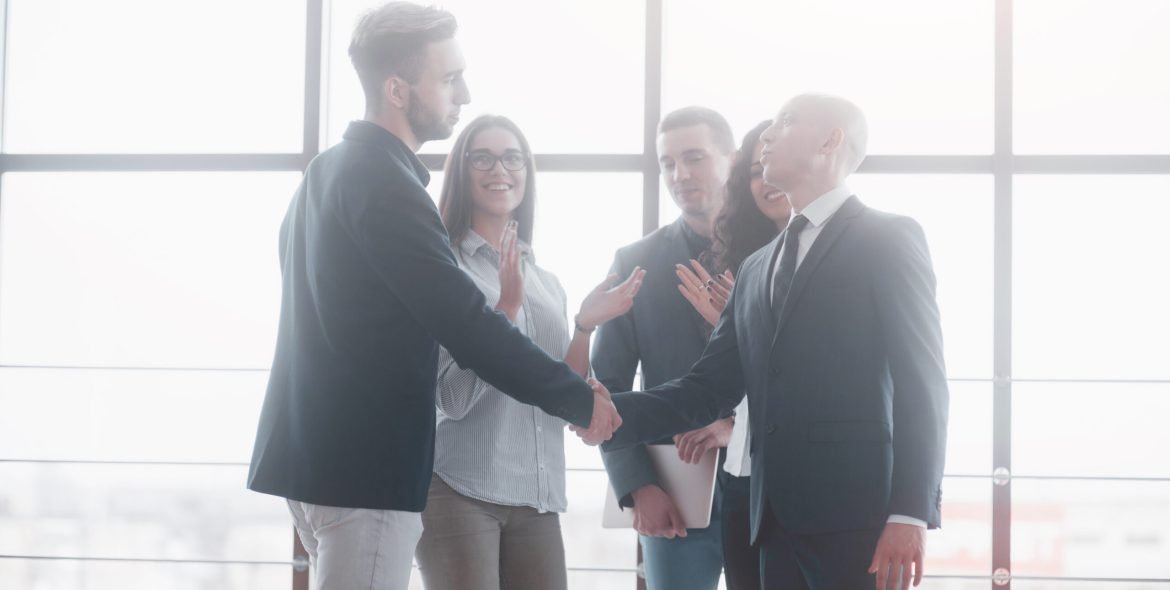 Two confident business man shaking hands during a meeting in the office, success, dealing, greeting and partner concept.