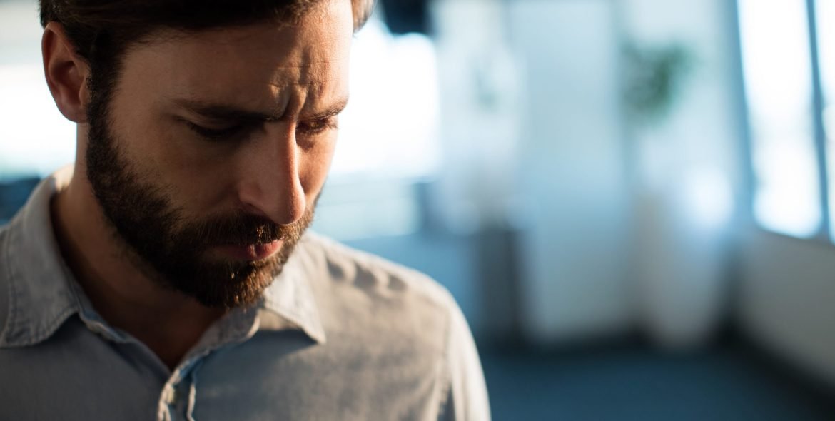 Upset businessman looking down at office