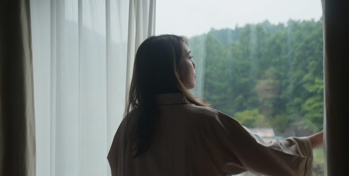 Woman wake up at morning and open the curtain at hotel room