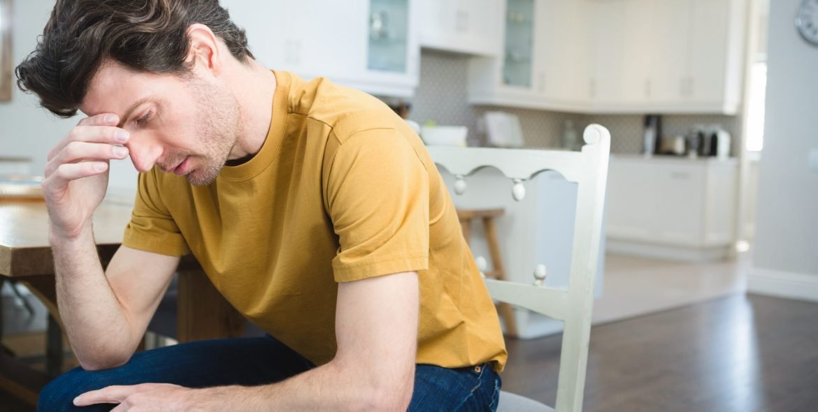 Worried young man sitting at home